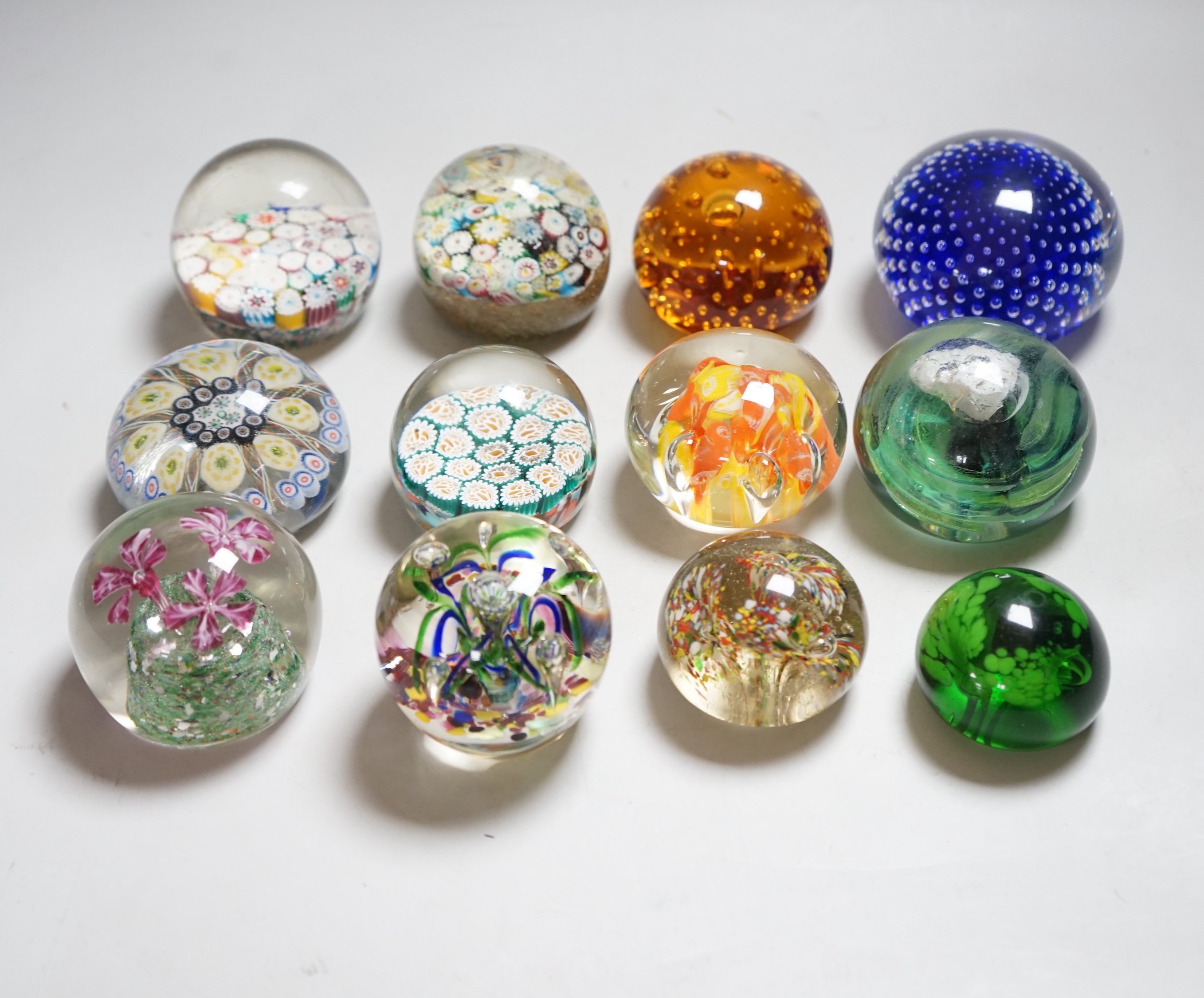 Twelve 20th century paperweights including Bohemian and Chinese examples, close packed millefleur canes, lamp work, etc.